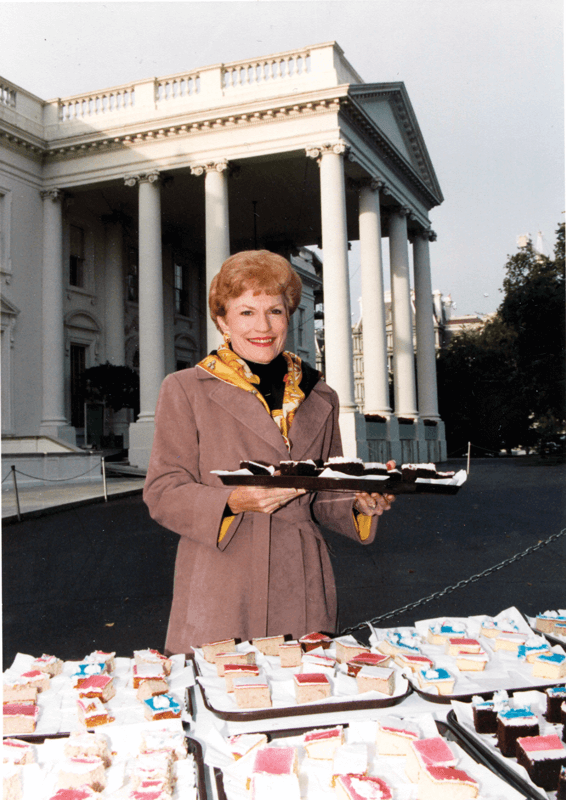 Ann McCoy offers birthday cake to tourtist that visited on the 200th birthday of the White House.