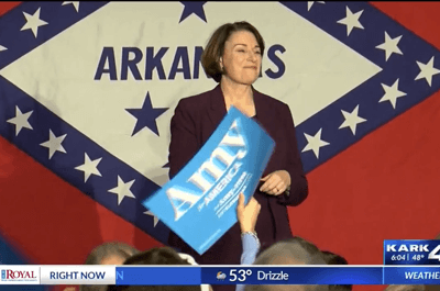 Klobuchar standing in front flags sold by FlagandBanner.com (KARK 4))