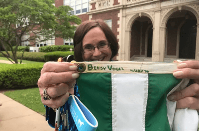 Betsy Vogel Boze shows where she sewed her name and the date she made the Earth Day flag now being flown at the school. (Photo: Jimmy Watson/The Times)