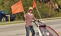 A pedestrian waves a flag while crossing a street. Courtesy St. Augustine Record