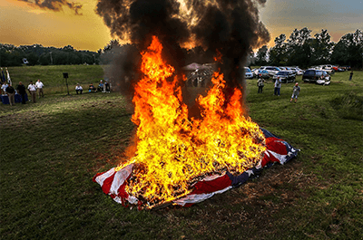 Thousands of American flags burn during a flag retirement ceremony by the Jeffersontown American Legion G.I. Post 244. Tens of thousands of American flags are under the large flag retired from Town & Country Ford. John Wright, with the post, believes that this flag retirement ceremony might be the largest in the U.S. June 29, 2019. (Photo: Michael Clevenger/Courier Journal)