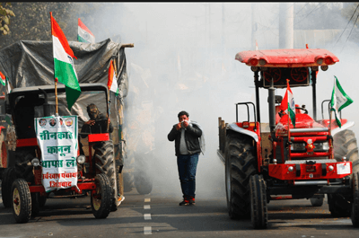 A farmer covers his face to protect himself from tear gas, during a protest against controversial farm laws introduced by the government, in New Delhi, India, January 26, 2021.