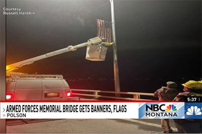 The Raven Hall motorcycle riding club hung flags and banners on the light poles to honor veterans on the Armed Forces Memorial Bridge in Polson this morning. Photo: Russell Harbin