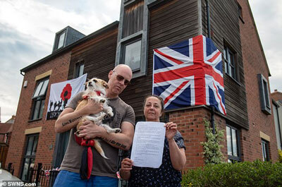 The couple pictured holding the letter outside their home in Shropshire. Mark, 45, said: 'I felt disappointed and had questions about whether to live here anymore' / SWNS.com