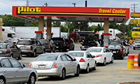 Cars line up at the Pilot Travel Center on Statesville Avenue to take part in a gas rebate offer through New Life Fellowship Center on Sunday afternoon. Pastor John P. Kee made the offer to church members during services, were given tokens to take to the station, and church paid $1 rebate for every gallon the members purchased. DAVID T. FOSTER III dtfoster@charlotteobserver.com