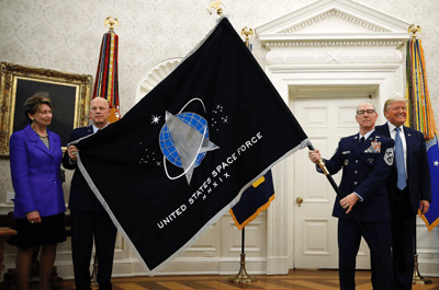 President Donald Trump stands as Chief of Space Operations at US Space Force Gen. John Raymond, second from left, and Chief Master Sgt. Roger Towberman, second from right, hold the United States Space Force flag as it is presented in the Oval Office of the White House, May 15, 2020, in Washington. Secretary of the Air Force Barbara Barrett stands at far left.  ALEX BRANDON/AP