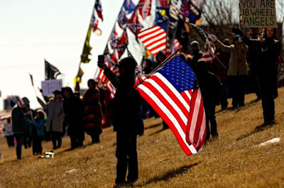 People gather along I-40 to show their support for truck drivers as the People's Convoy passes through Yukon, Okla. on their way to Washington D.C. on Sunday, Feb. 27, 2022. (CHRIS LANDSBERGER/THE OKLAHOMAN)